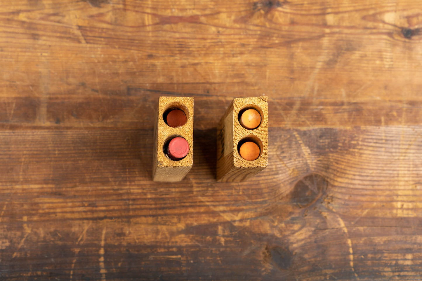 A flatlay photo taken from above of two vintage test tubes in wooden holders.